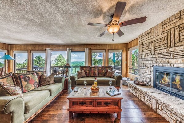 Relax in the spacious living room, complete with a cozy fireplace and stunning views of nature — the perfect spot to unwind and enjoy the serenity.