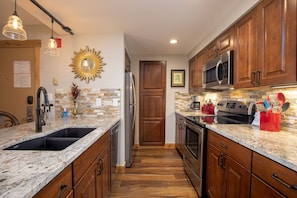 Full size kitchen featuring granite counter tops and stainless steel appliances.