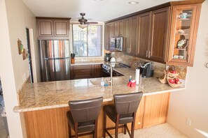 Full kitchen with view out to the lanai, golf course  and ocean beyond.