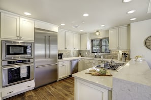 This gourmet kitchen has it all - Thermador commercial appliances, farmhouse sink, large island bar and pantry.