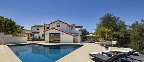 Outdoor space stuns with large pool and adjacent hot tub