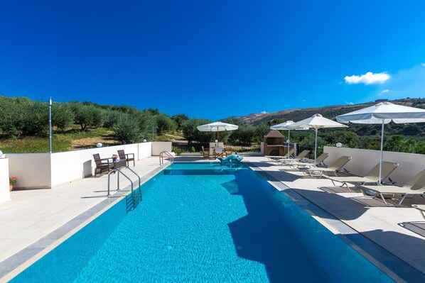 Pool area with umbrellas and sun beds.