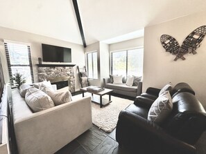 Gather, relax, and reconnect in this open-concept living area with soft seating and the glow of a traditional log fireplace