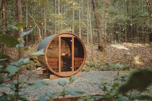 Relax in a cozy outdoor barrel sauna, surrounded by towering pines. This luxury sauna retreat offers the perfect way to unwind after hiking or exploring. Enjoy the warmth and serenity of nature in a peaceful forest escape, ideal for ultimate relaxation.