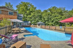 Heated in-ground pool with large seating area and outdoor kitchen.