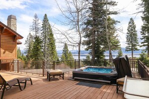 Front decking with seats and hot tub perched mid-mountain with expansive lake views.