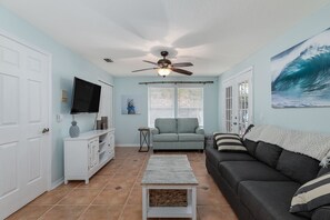 Cozy living room w/ 50” smart tv and windows that look out to the pool