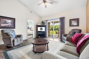 The living area is spacious and features cable TV, 2 recliners, a queen-sized sofa sleeper, and access to the deck