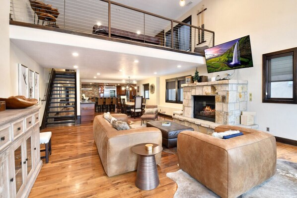 Living Room with Comfortable Seating in front of the Gas Fireplace and Smart TV looking toward the Kitchen on Main Level (2nd)