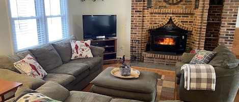 Living room #1 has wood stove fireplace and large flat screen TV.