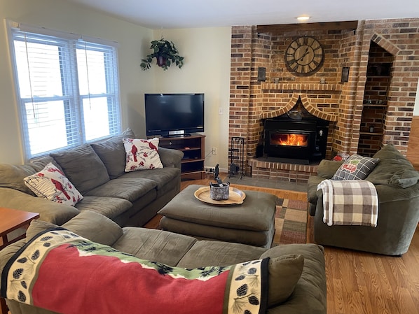 Living room #1 has wood stove fireplace and large flat screen TV.