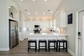Kitchen bar seats 4 with built-in trash bins for easy cleanup.