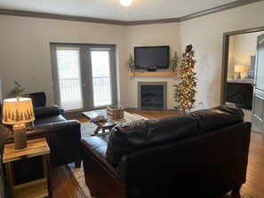 Living room features a fireplace and a TV with access to the outdoor balcony