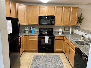 Fully stocked kitchen with granite counter tops & modern appliances for cooking