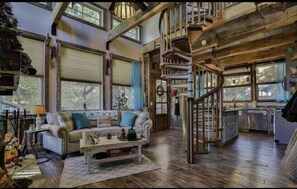 Spiral staircase in living room area lead to loft bedroom w/ 4 twin beds. 