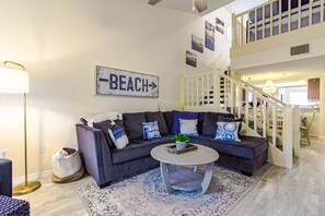 Spacious living room with corner sofa, colorful pillows and Smart TV with cable & WiFi Included.  New wood tile flooring throughout!