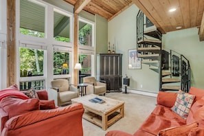 Living room with spiral staircase leading to two upstairs bedrooms