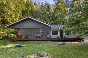 Front showing covered and open deck w/ 6 seating dining table, firepit and BBQ