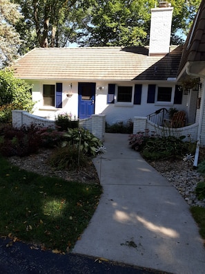 Walking up the sidewalk to the home.