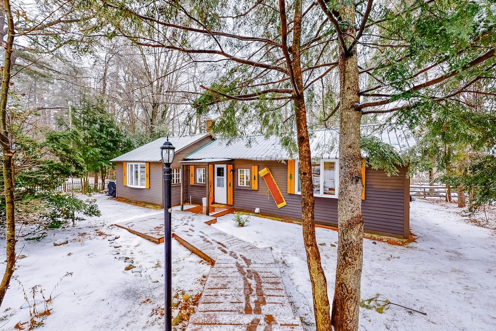 A New Hampshire vacation rental sits in a snowy opening in the woods