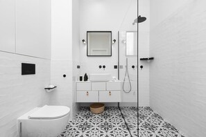 Bathroom with washing machine and towels. 