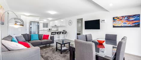 A large modern living area with contemporary fittings and decor and a 55" TV.