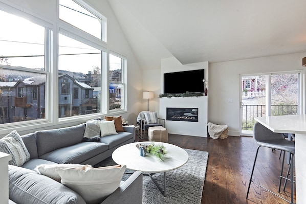 Living Room with plenty of seating, big screen TV and fireplace.