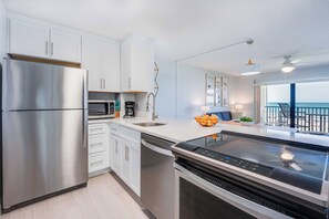 Sleek and modern kitchen equipped with stainless steel appliances and a scenic balcony view.