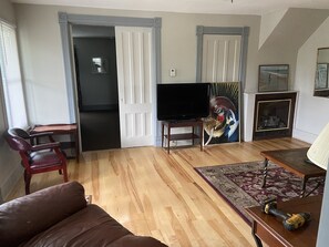 Living room with large couch and comfy chair, fireplace, tv, roku & central Air 