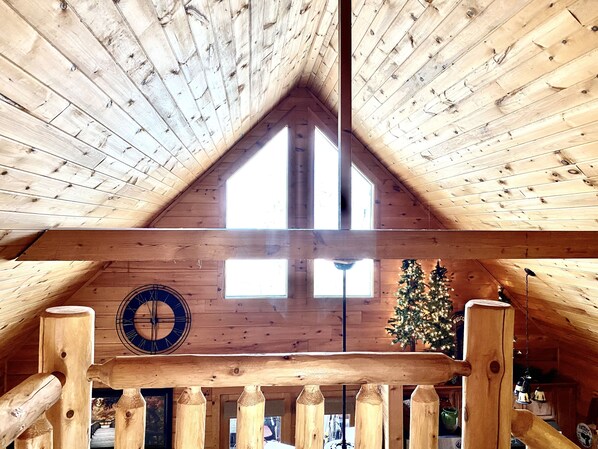 Cathedral ceilings frame windows allowing glowing natural light and night sky.
