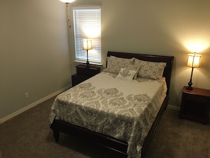 large master bedroom with queen bed attached bathroom and large walk-in closet.