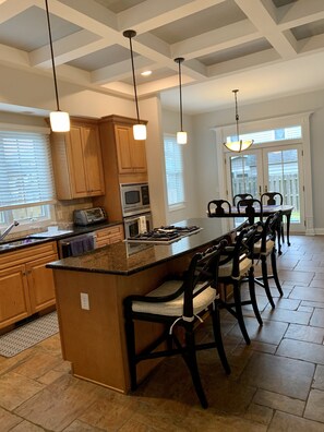 Large well appointed kitchen with island seating for 3 and dining area