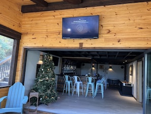Panoramic doors opening from downstairs bar to beautiful new screened-in porch