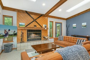 Living room with door to back deck, surrounded by open space, nature and gorgeous views.