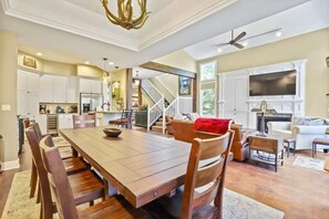 The view from the beautiful dining area with its spacious table with seating for eight and striking antler chandelier highlights its ideal location just off of the living room and kitchen.
