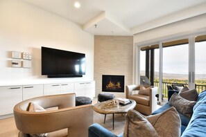 Another View of The Main Floor Great Room With a Fireplace and 65" Smart TV Right Off the Balcony