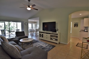 Living room with 65" TV  overlooking kitchen and dining room