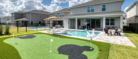 Home's fenced backyard with putting green and private swimming pool 