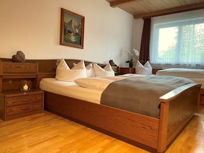 Schlafbereich. 1 Dreibettzimmer_Bettwäsche_ Sicht zum Garten_ Vorhänge für Verdunkelung_