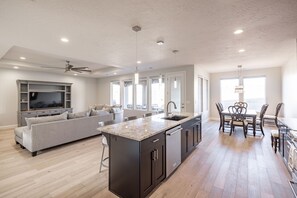 Kitchen View - Side view of kitchen showing off the beautiful counter tops and stainless-steel appliances.