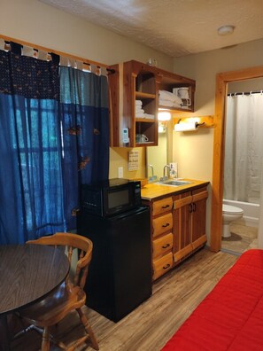 MAIN ROOM:  Includes a full-size bed, table, and small sink / kitchenette.