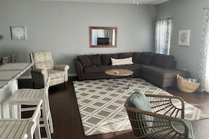 Spacious den with comfortable sofa and a balcony to enjoy the outdoors. 