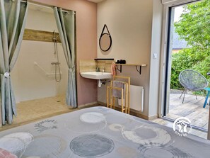 Chambre 1 (13.4m²) : lit 160x200 cm, étagère avec penderie, salle d'eau privative accessible PMR, terrasse privative avec table et 2 chaises – H53G019299 - La Rose Trémière à Cossé-le-Vivien – Gîtes de France Mayenne