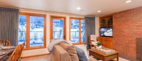 Bright and spacious living room with fireplace and large floor-to-ceiling windows