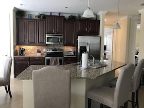 Large kitchen with stainless steel appliances and dark wood cabinets