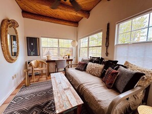 Light filled sunroom with daybed and workstation/desk