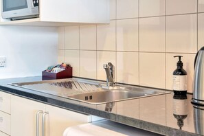 The kitchenette area has a microwave, fridge/freezer, kettle and toaster.