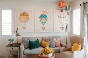 Up Up and Away in this charming living space with comfy seating and whimsical hot air balloon artwork.
