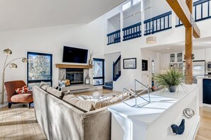 Living room showing stairs that lead to upper level.