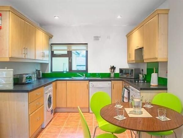 Fully fitted well equipped kitchen has crockery and utensils with oven, hob, microwave, dishwasher, washer/drier